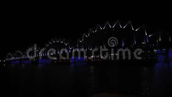 在里加的黑夜明亮蓝灯的铁路桥景视频的预览图
