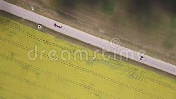 从空中俯瞰公路车辆行驶一辆车停在黄灰相间的田野中视频的预览图