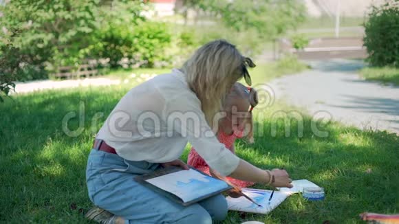 教师与幼儿一起在户外绘画课视频的预览图