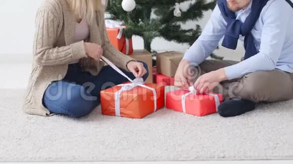 圣诞节和新年的概念快乐的年轻夫妇打开圣诞礼物视频的预览图