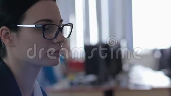 工作时紧张工作时戴眼镜的疲惫的年轻女子在办公室做特写视频的预览图