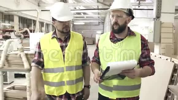 家具厂两名穿反光背心和头盔的工人视频的预览图