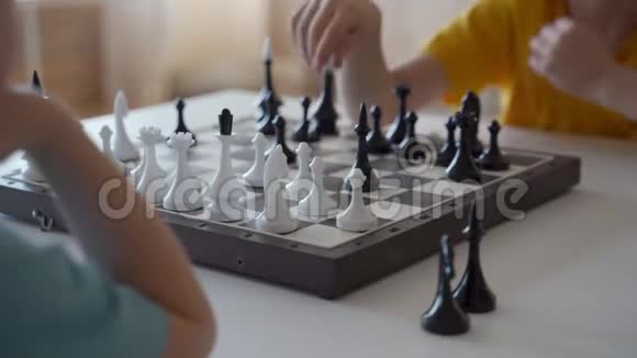两个男孩在灯光室下棋两个兄弟在下棋视频的预览图