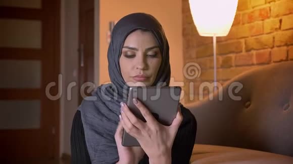 使用平板电脑拍摄成年穆斯林女性戴头巾的特写照片并在拍摄时显示绿色屏幕视频的预览图