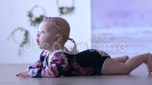 婴儿生活可爱的婴儿躺在地板上在没有聚焦的背景下看着室内的距离视频的预览图