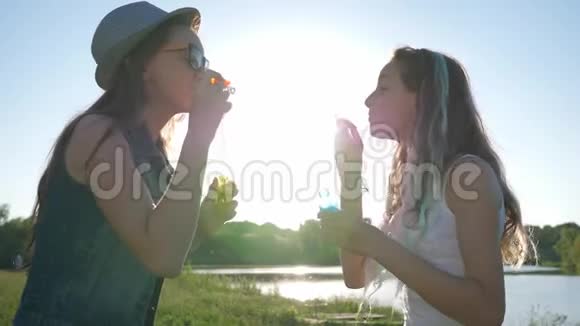 有肥皂泡的快乐女朋友在阳光下和大自然在一起视频的预览图