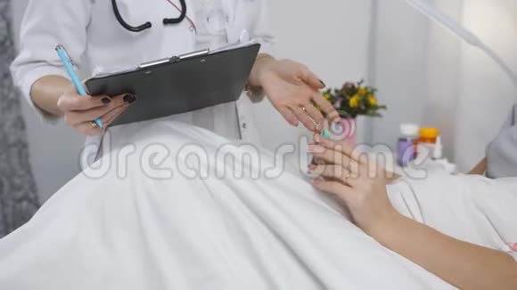 医生和躺在医院病房床上的女人说话医生给病人开药视频的预览图