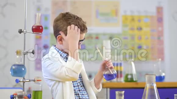 可爱的男孩在实验室里用液体开始实验视频的预览图