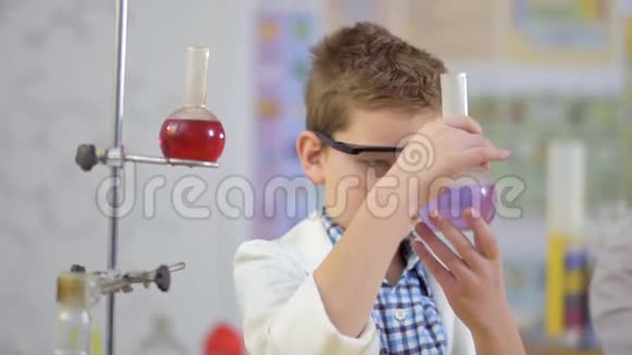 年轻的科学家用紫色的液体盛瓶视频的预览图