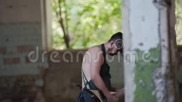 破碎的废弃工厂这位吉他手在这座废弃的破建筑的地盘上演奏视频的预览图