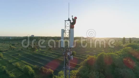 通信塔与承包商检查移动连接上的蜂窝天线在蓝天背景下视频的预览图
