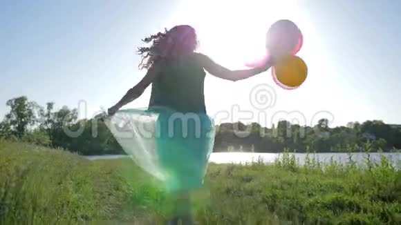 现代的少女头发上有一股黑色的卡尼卡龙手里拿着球走在大自然中洛夫视频的预览图