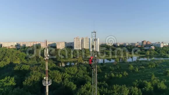 承包商在美丽的城市景观背景下在高度上工作在电信桅杆上无人机可以看到视频的预览图