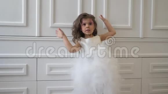 名人小女孩穿着蓬松的连衣裙脸上有亮片背景是白色的墙壁视频的预览图
