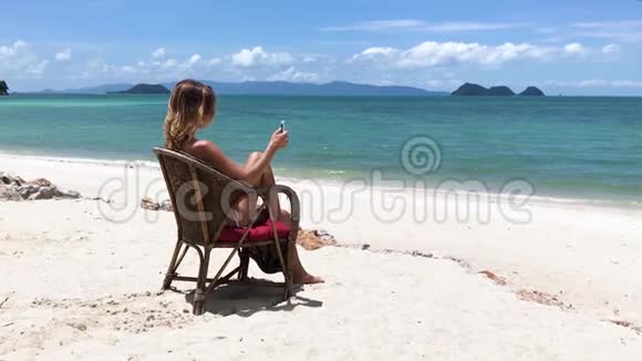 那个年轻漂亮的女人坐在海边的椅子上视频的预览图
