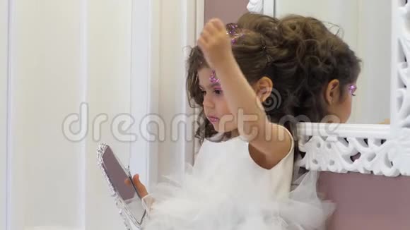 留着漂亮发型和亮片的小个子在家里手里拿着小镜子视频的预览图