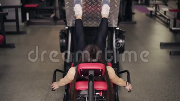 后面的镜头显示一个身材臃肿的黑发女孩在健身房锻炼腿部健康的生活方式健身和视频的预览图
