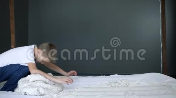 快乐无忧无虑的男孩在床上慢动作翻筋斗视频的预览图
