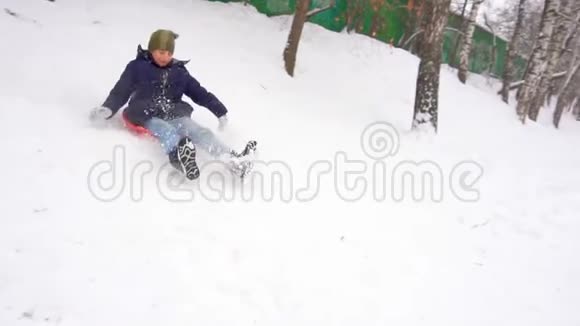 骑着雪山的男孩冬天的乐趣慢动作视频的预览图