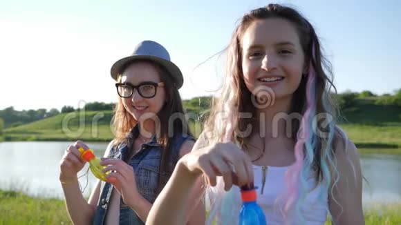 可爱的女孩带着肥皂泡兴高采烈地花时间在草地上视频的预览图