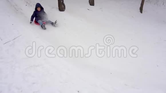 骑着雪山的男孩冬天的乐趣慢动作视频的预览图