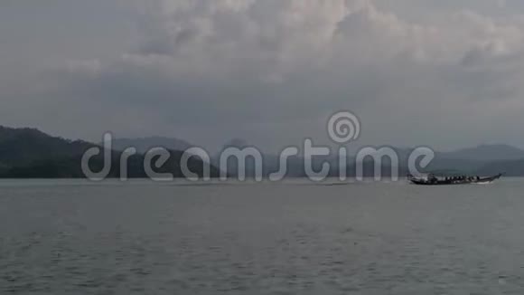 乘用传统的泰国木制长尾艇穿越水湖视频的预览图