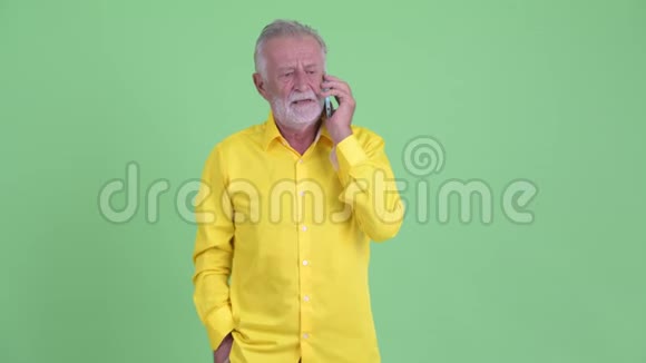 快乐的老胡子商人在打电话视频的预览图