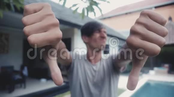 拇指向下双手由年轻人在家在院子里户外不同意的概念视频的预览图