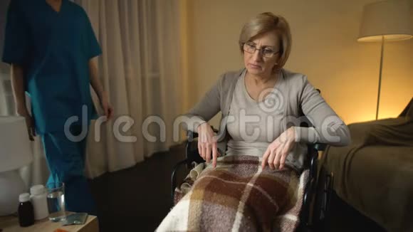 女性护理者给坐轮椅的住院病人吃药康复视频的预览图