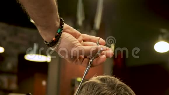 理发师用剪刀特写剪了客户的头发视频的预览图