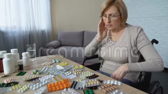 伤心的老妇人把药片从桌子上扔下来哭健康问题抑郁视频的预览图