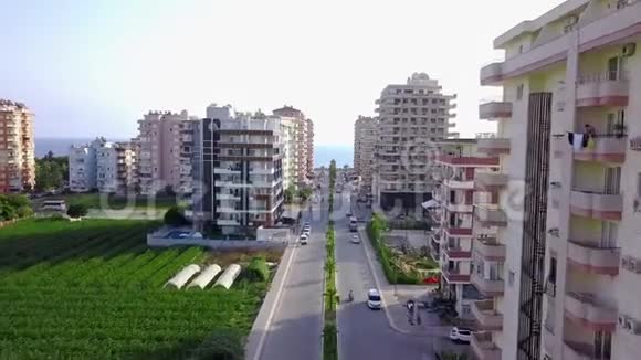 通往大海的城市道路的俯视图剪辑穿过城市高层建筑的道路通向地平线上的大海顶级视频的预览图