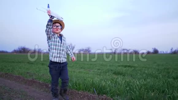 童年戴眼镜戴帽子的人在田里玩玩具飞机视频的预览图