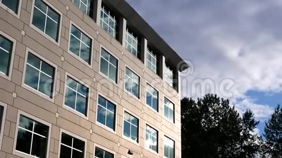 多云的天空现代办公大楼上有明亮的反射玻璃立面视频的预览图