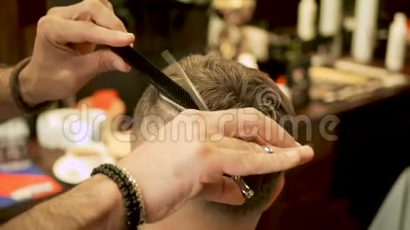 理发师用剪刀特写剪了客户的头发视频的预览图