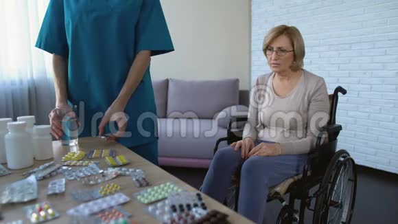 医院护士给轮椅治疗常规中的女性病人服药视频的预览图