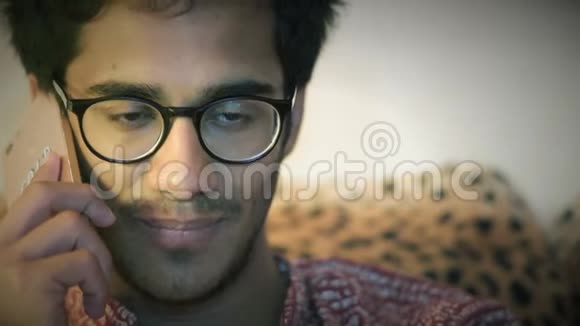 特写镜头戴眼镜的印度男人在沙发上坐在家里视频的预览图