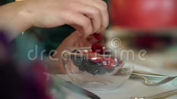 中年妇女从盘子里拿树莓视频的预览图