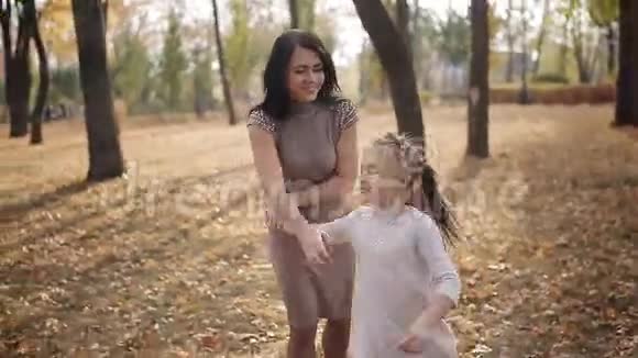 妈妈和她心爱的女儿围着自己转一家人在公园玩得开心视频的预览图