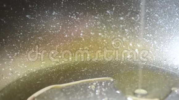 植物油橄榄油或向日葵倒入一个细流中涂有特氟龙涂层的煎锅中加热和烹饪视频的预览图