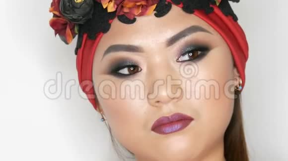 高级时尚一位美丽的亚洲女孩模特的肖像她身着红色头巾戴着鲜艳的妆容戴着花环视频的预览图