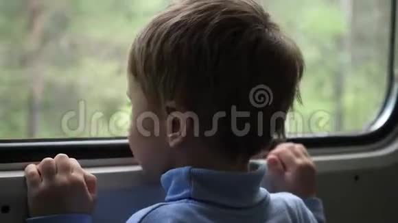 这个男孩坐火车旅行望着窗外看着窗外移动的物体旅行与视频的预览图