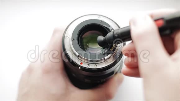 摄影师用一支专业的铅笔把现代镜头的背面从污垢和指纹中清除出来视频的预览图