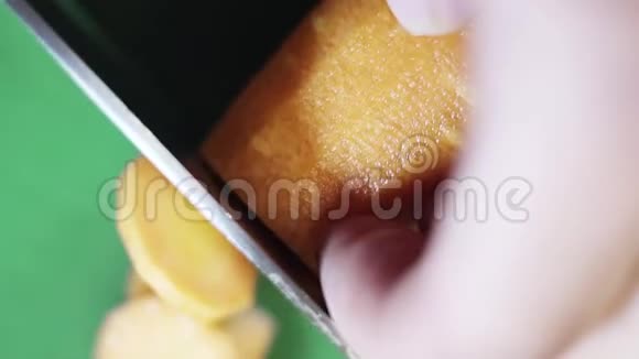 橙色胡萝卜正在绿色餐桌上用锋利的大刀切薄片视频的预览图