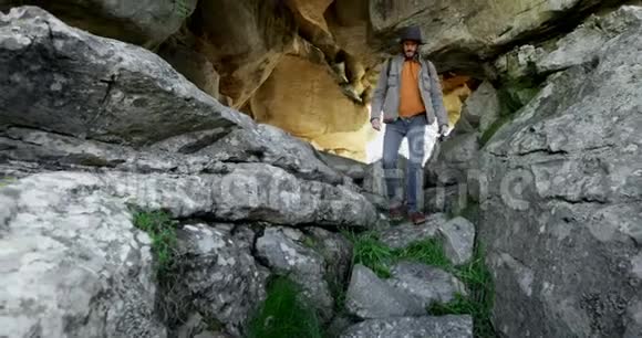 男徒步旅行者4k从山洞里走出来视频的预览图