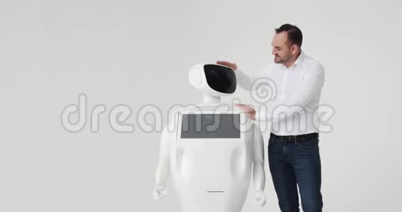 男人抚摸机器人和机器人的友谊现代机器人技术一个男人和一个机器人交流视频的预览图