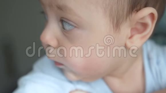 可爱的婴儿脸棕色的眼睛在镜头特写镜头中婴儿的样子视频的预览图