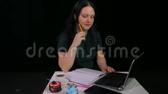 一个黑发女孩在咖啡馆工作与电脑和喝咖啡在咖啡馆视频的预览图
