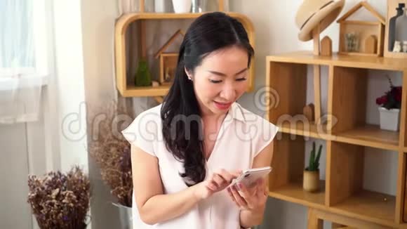 微笑着快乐的亚洲少女和亚洲中年母亲拥抱在家里的室内客厅视频的预览图