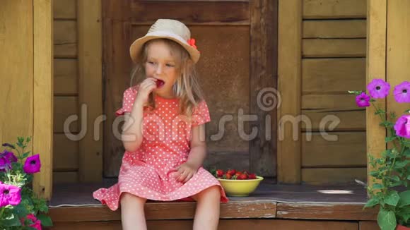 吃新鲜草莓的草帽小女孩视频的预览图